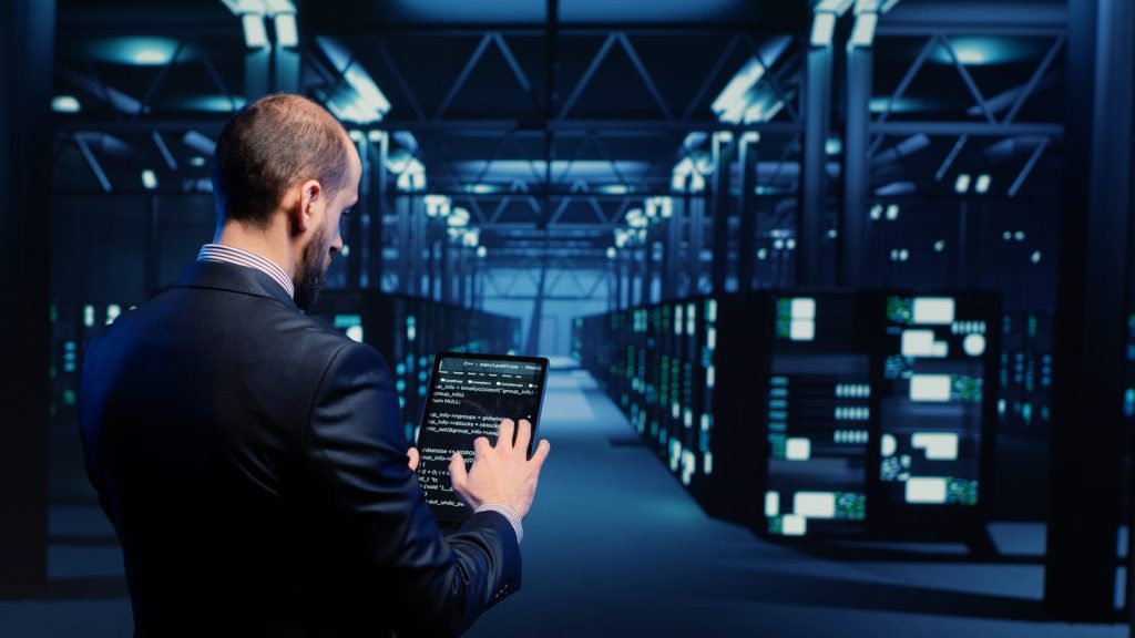 Ingénieur d'un datacenter faisant des réglages sur une baie de serveurs.